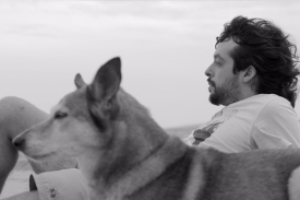 still from film, man and dog on the beach